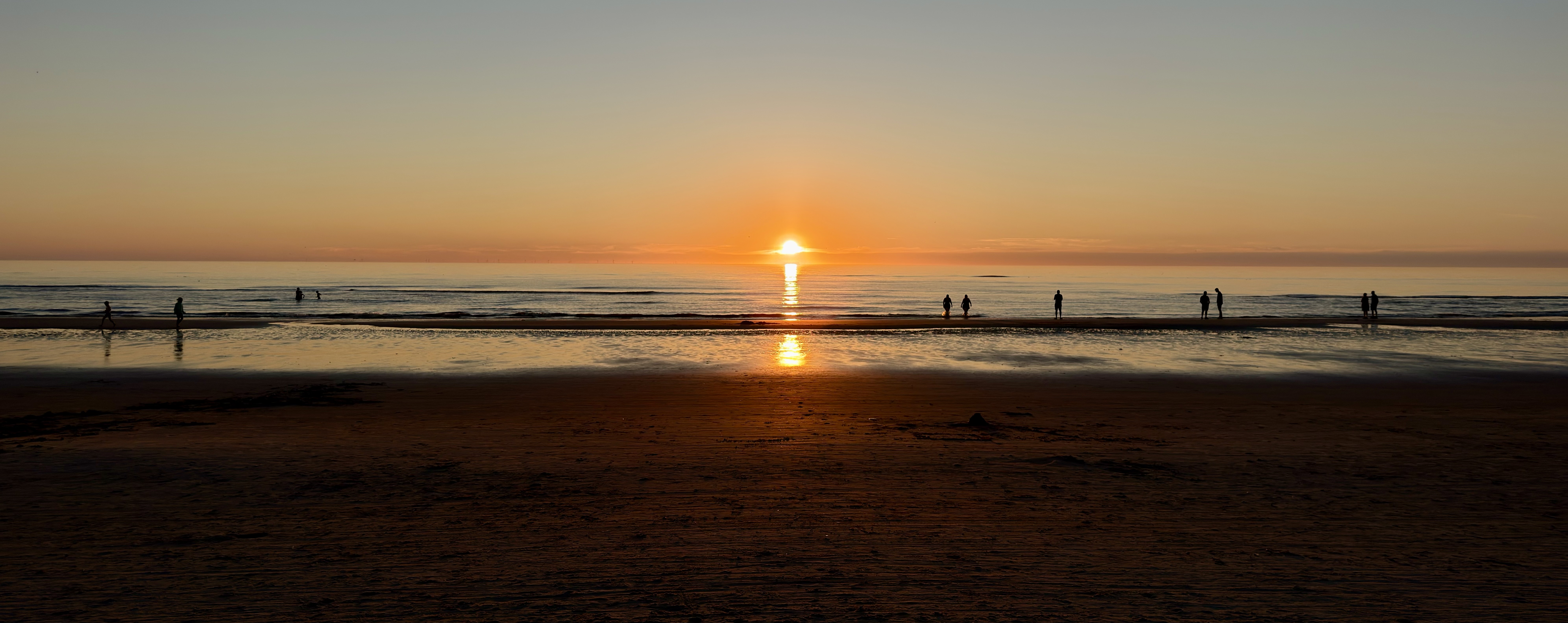 Red-orange sunset over the North Sea with dark clouds catching the light