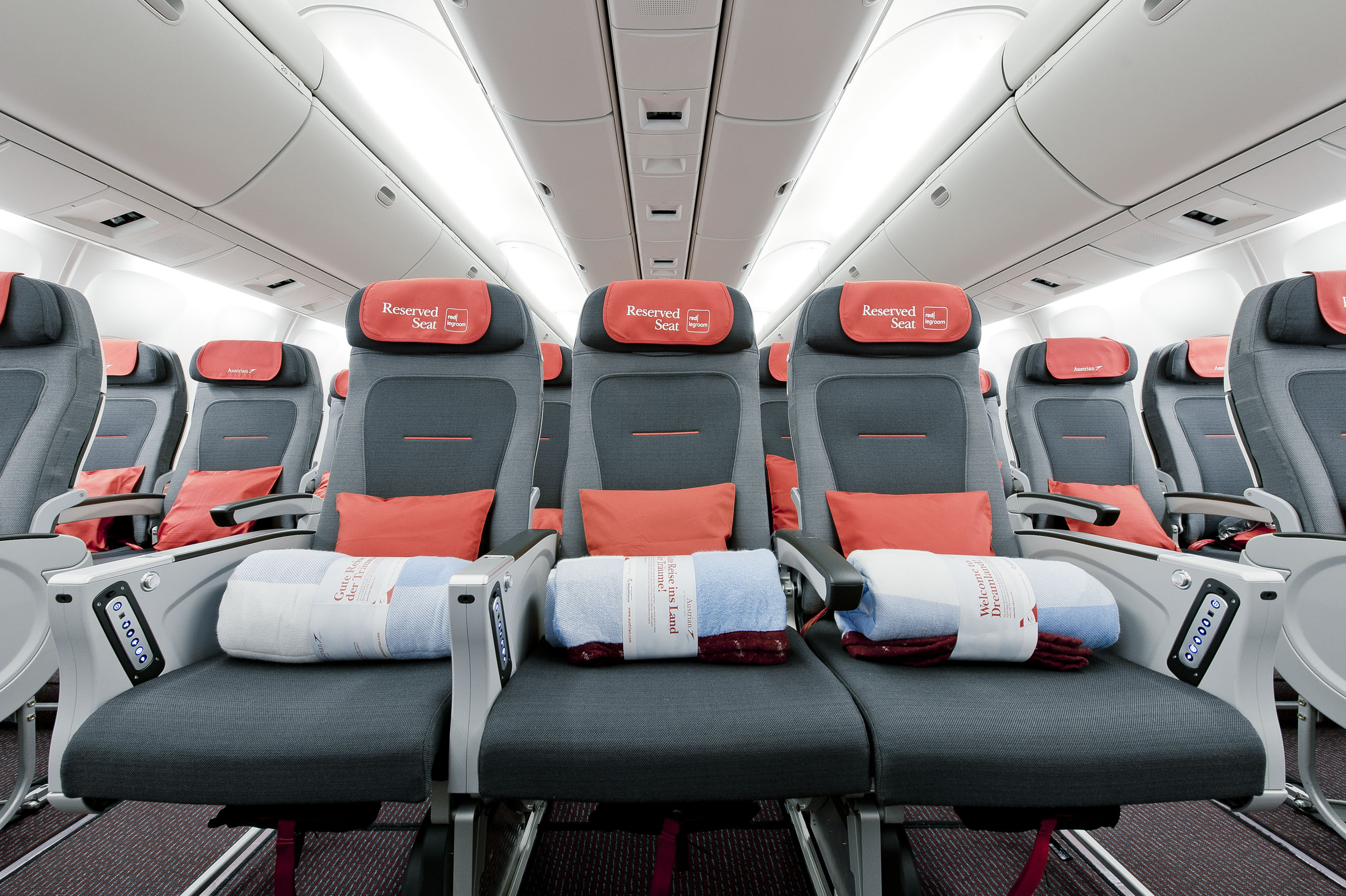 The interior of a long-haul aircraft cabin with rows of economy seats
