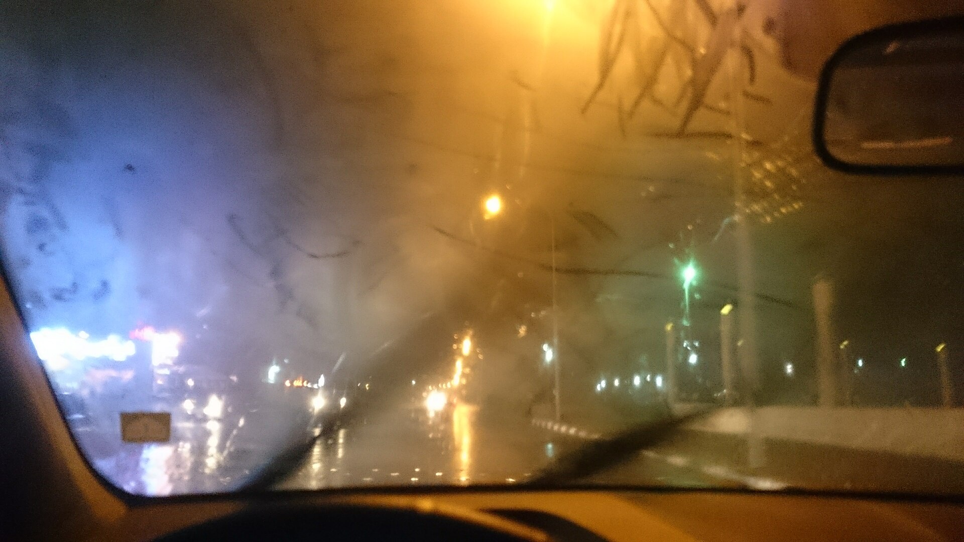 Fogged car windscreen seen from the driver's seat at night