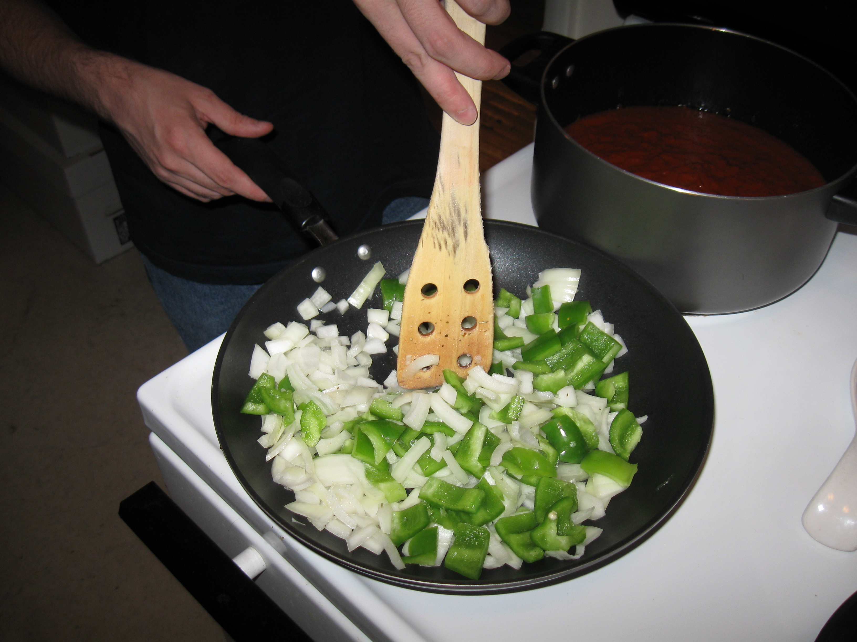 Sautéed onions and peppers cooking together in a pan