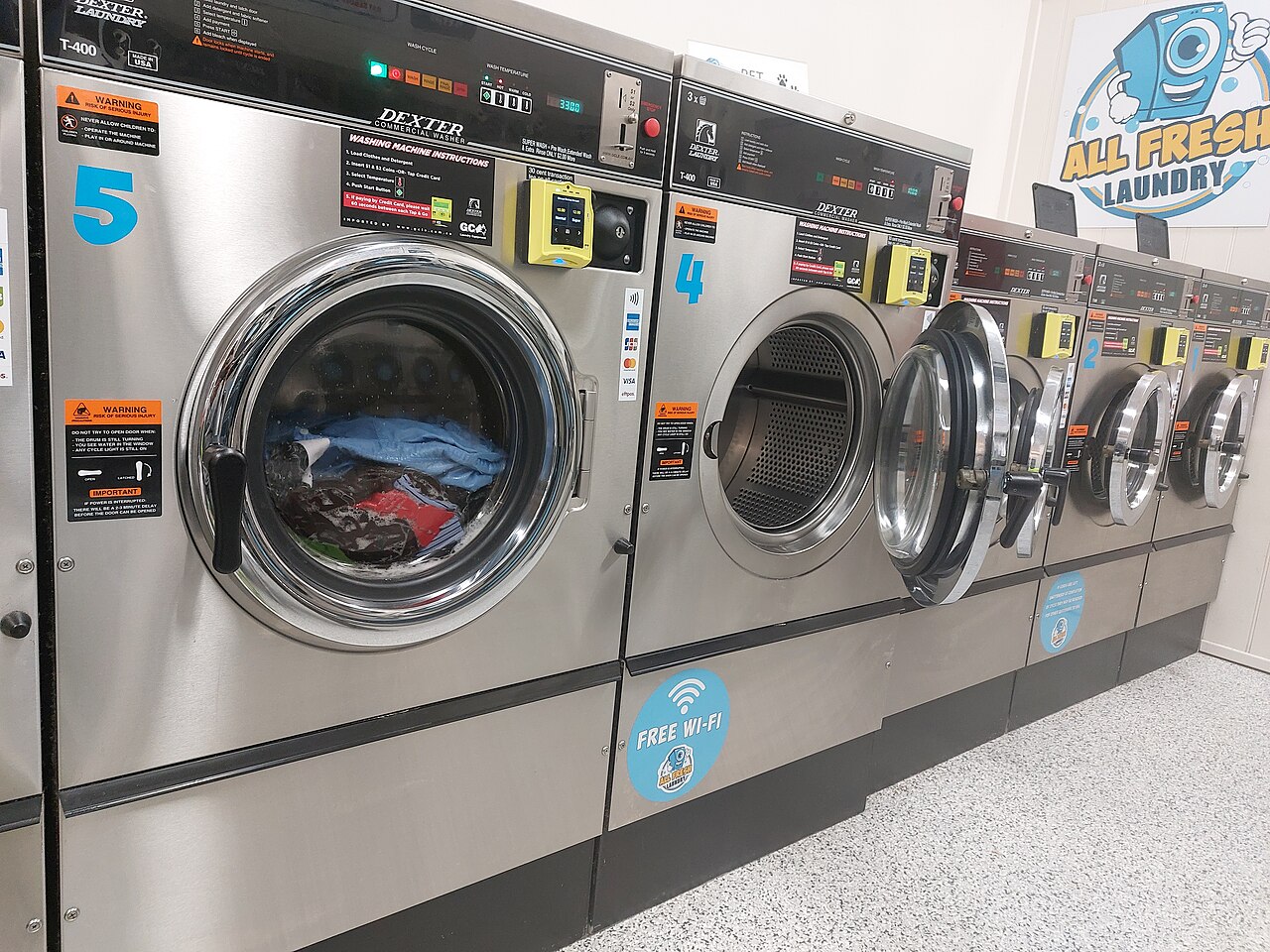 A row of commercial washing machines in a laundromat