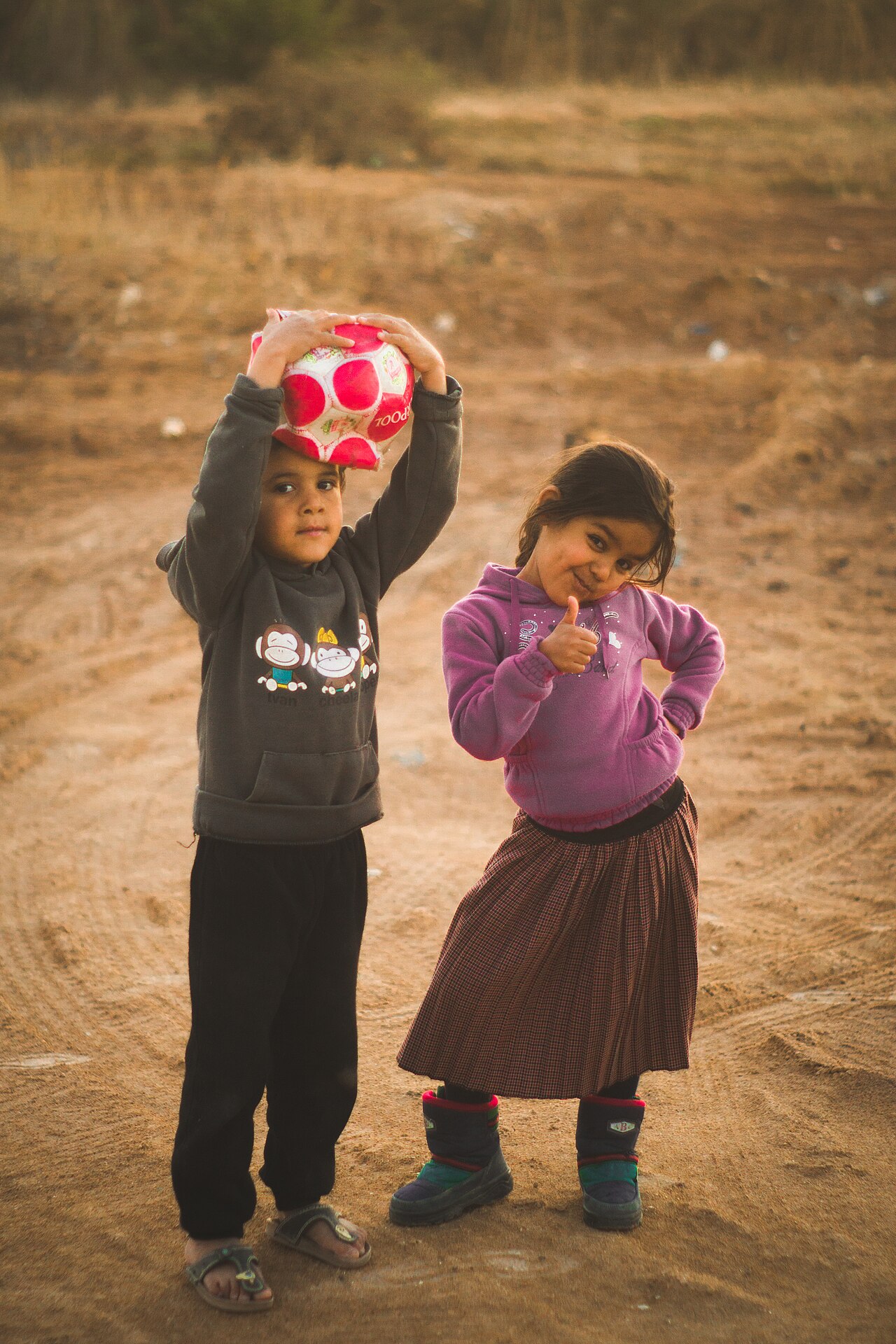 Two children playing with a ball outdoors