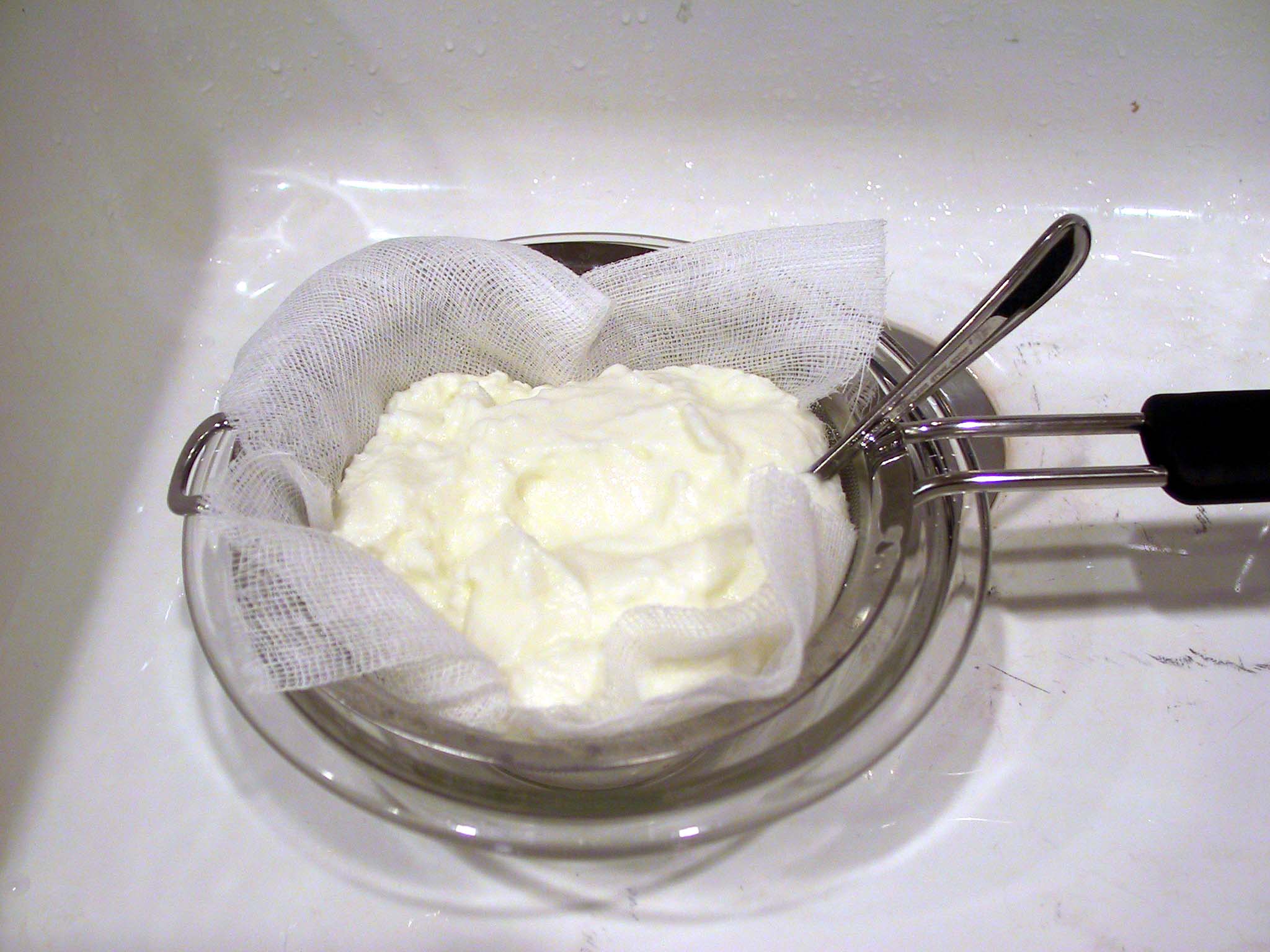 Smooth white curd in a steel bowl, showing the uniform texture of fresh yoghurt