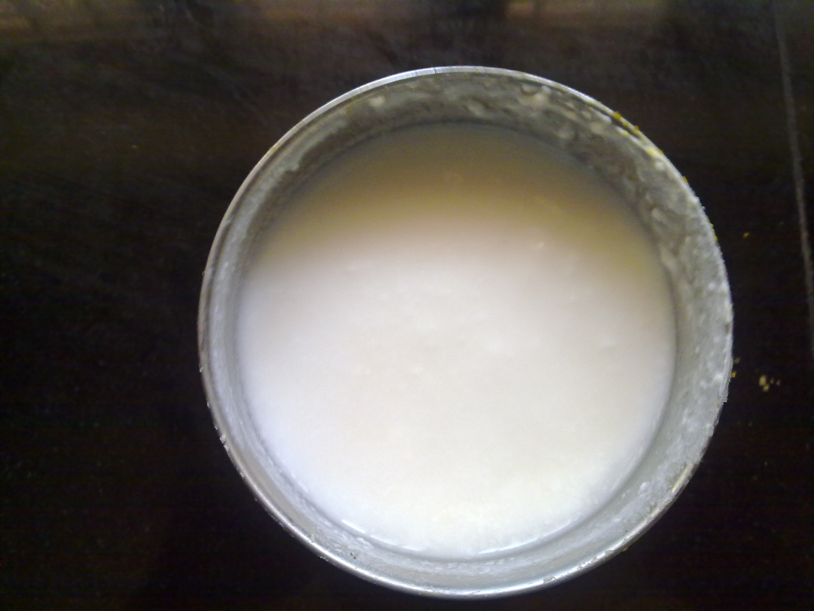 Yoghurt straining through cheesecloth in a sieve over a glass bowl