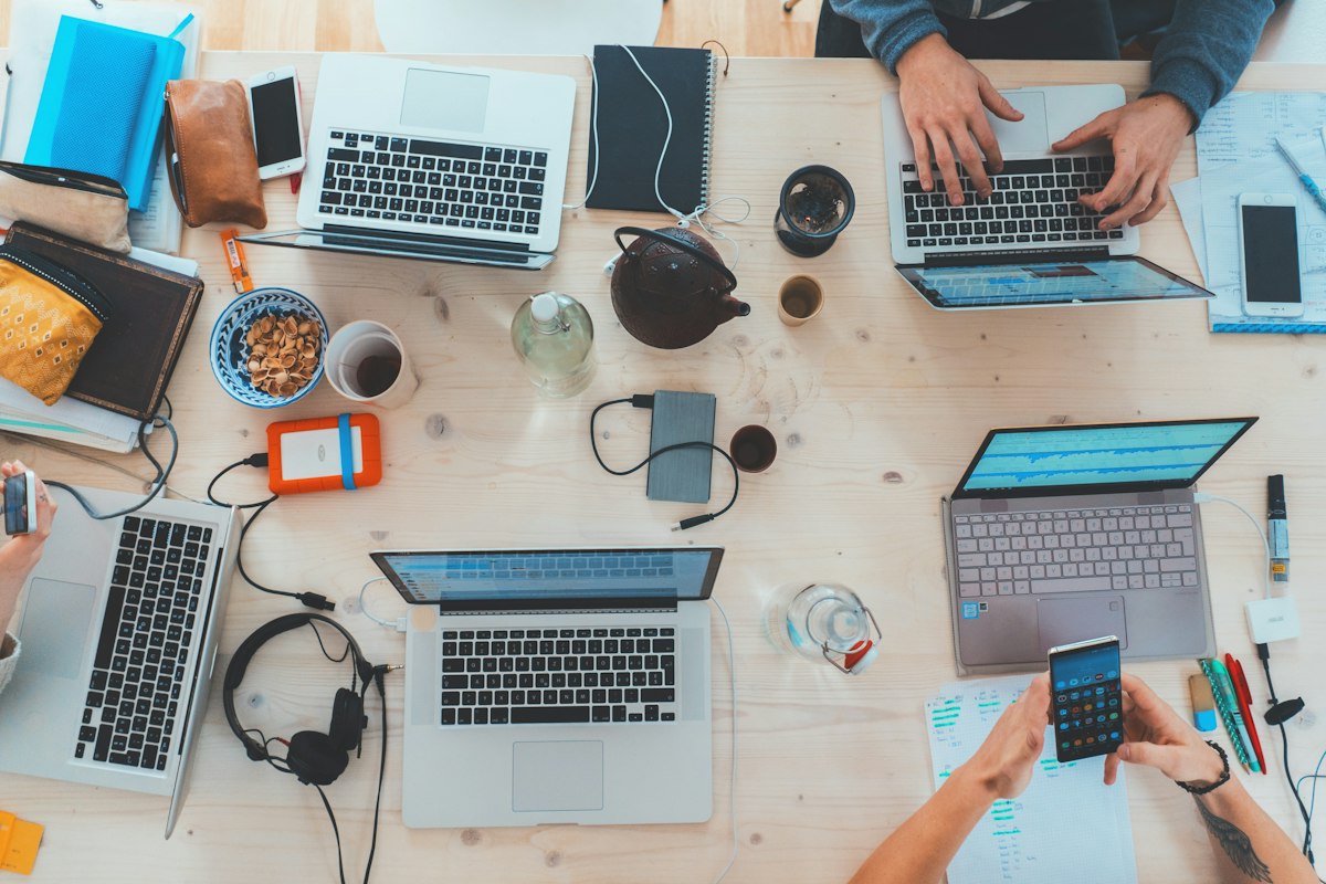 Intern working with colleagues on laptops in a shared office space