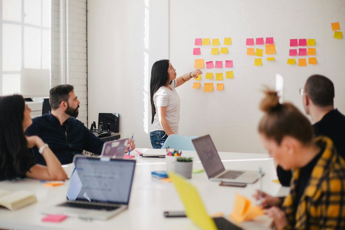 Interns discussing work in a meeting room with their manager